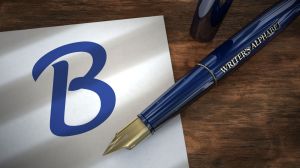 Fountain pen resting on piece of paper with the capital letter B