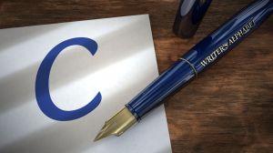 Fountain pen resting on piece of paper with the capital letter C